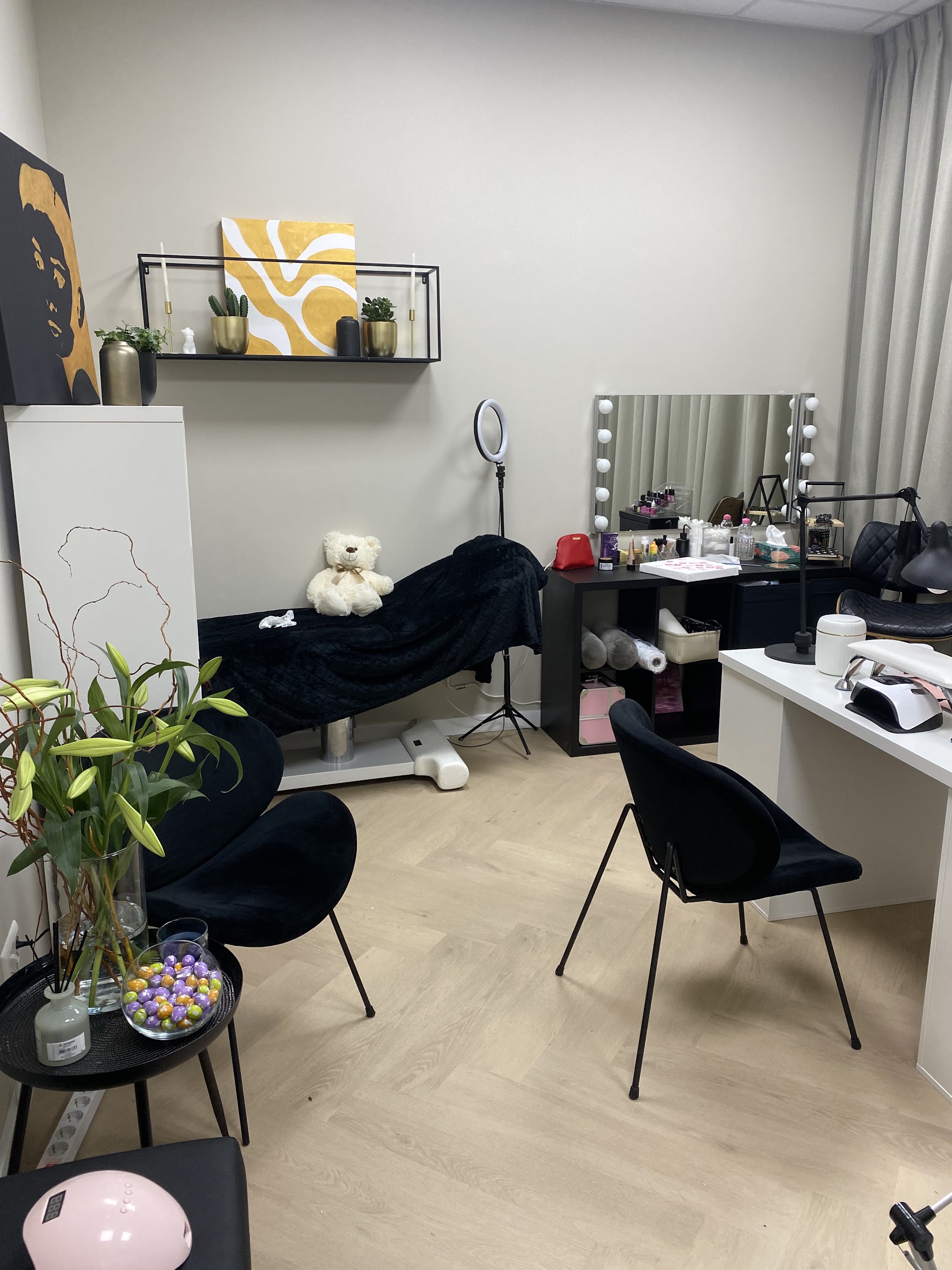 De studio van Okshen Art Bar: behandelstoel, werktafel met lamp, spiegel met lampjes en planten